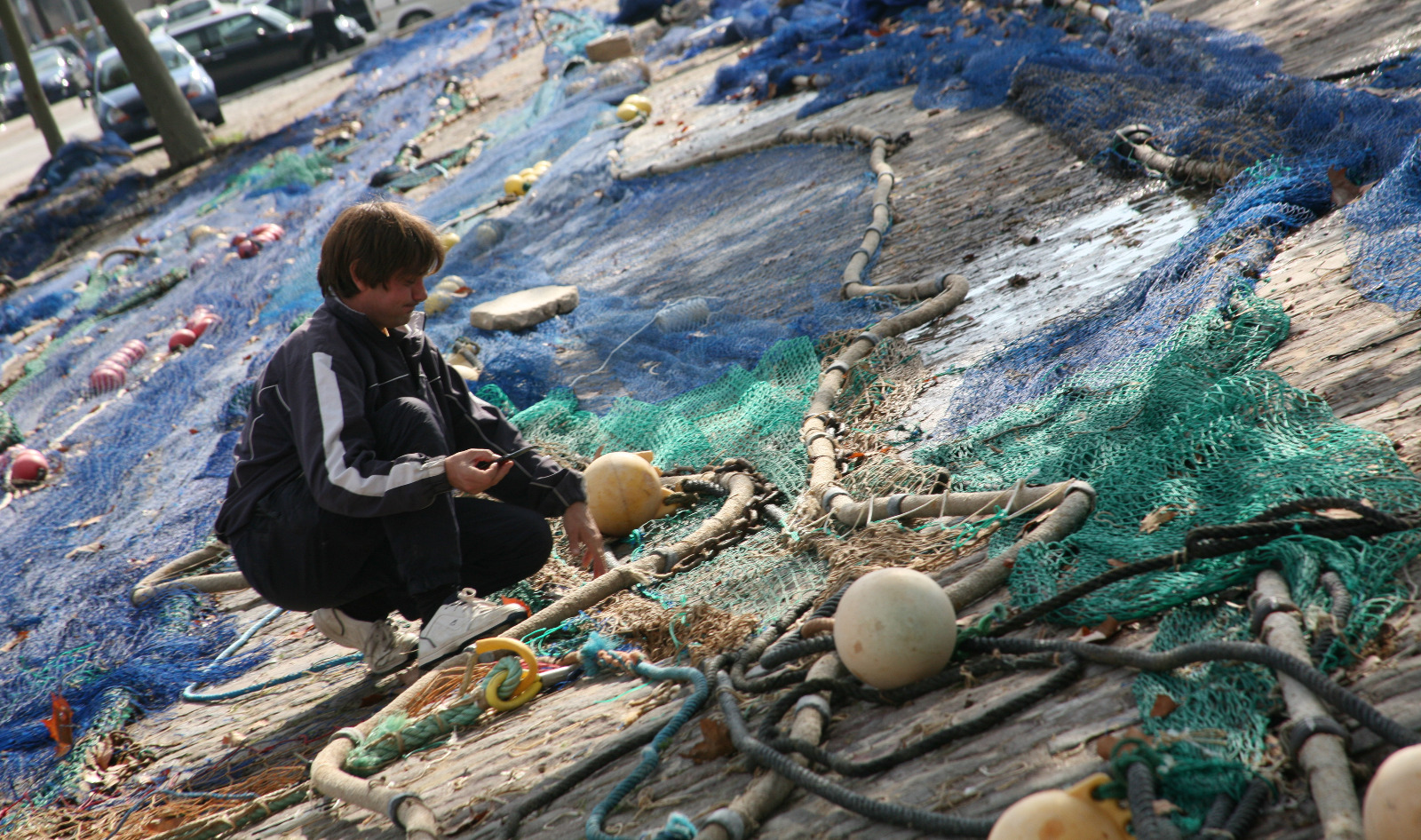 Un home fa feina sobre unes xarxes de pesca